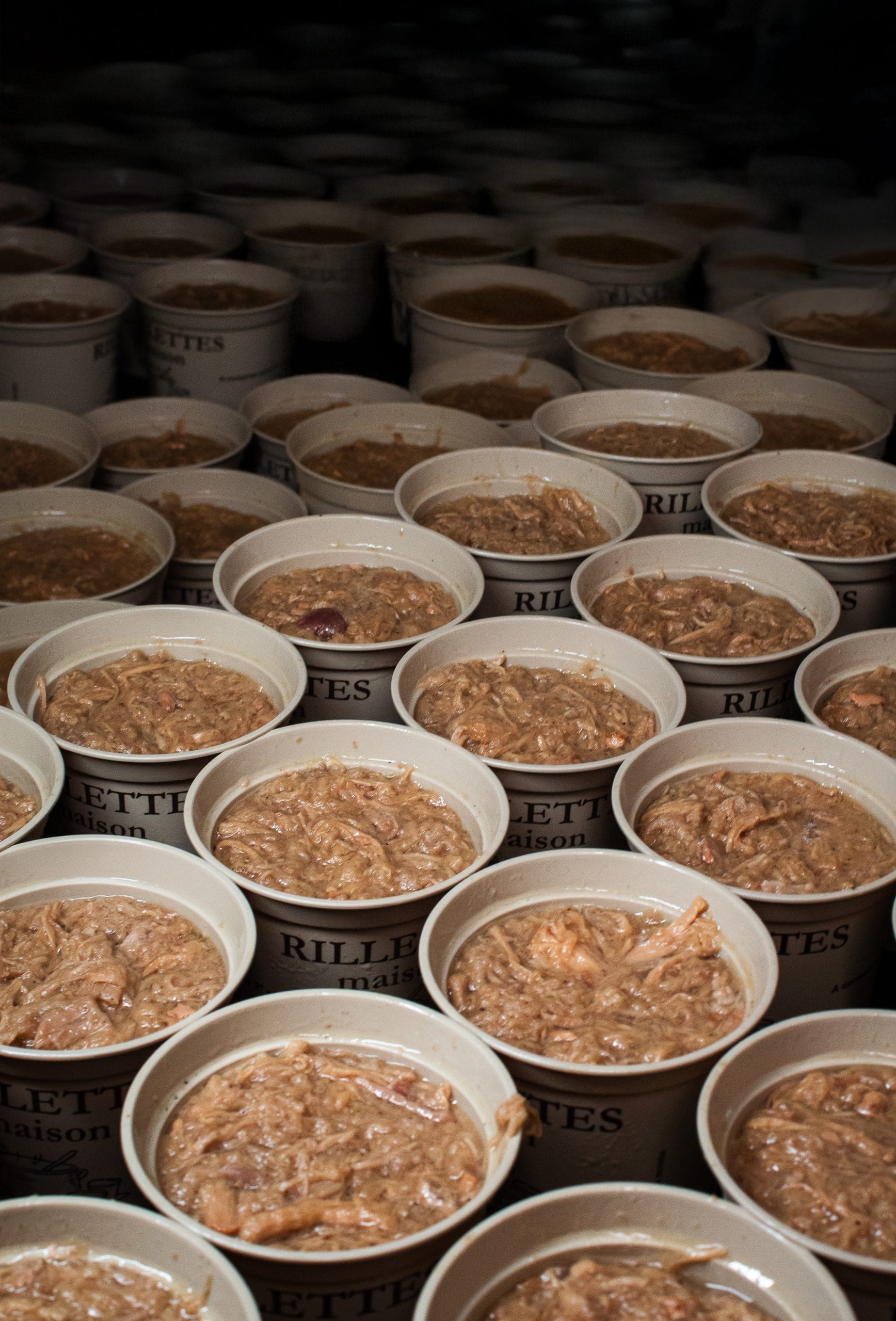 Pots de rillettes maison La Sarthoise alignés en rangées, production artisanale